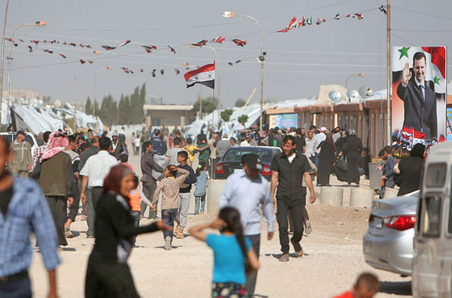A Syrian flag and a photo of Syrian President Bashar Assad are seen in Herjelleh shelter in Damascus countryside, Syria, on April 15  (Reuters photoa)