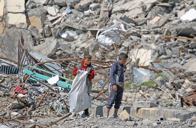Boys stand on the rubble of damaged buildings in the former Daesh stronghold of Raqqa, Syria, on Wednesday (Reuters photo)