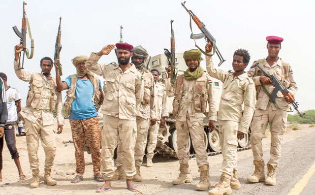 This photo taken on Friday shows Sudanese soldiers fighting alongside Yemen's Saudi-backed pro-government forces against the Houthi rebels as they salute with their hands and firearms before a tracked vehicle on the side of a road near Al Jah, about 50 kilometres southwest of the Red Sea port city of Hodeida (AFP photo)