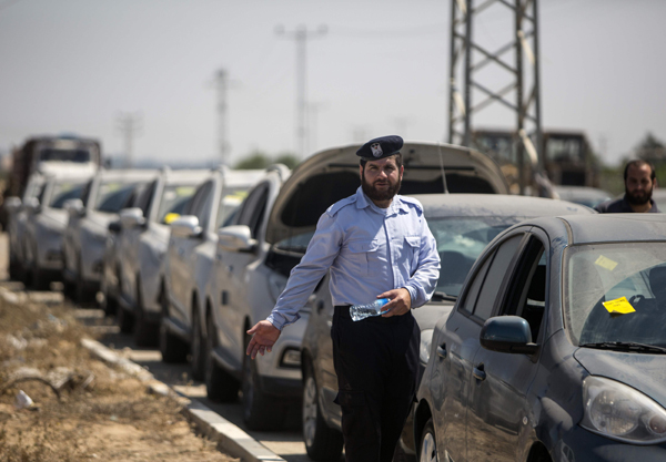 A Palestinian Hamas security person inspects vehicles that came from Israel to serve the Gaza Strip market on Thursday in the Palestinian side of the Erez crossing with Israel (AFP photo)