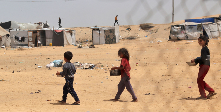 Displaced Palestinian children carry containers with food in Rafah, on the southern Gaza Strip, on May 19, 2024, amid the ongoing Israeli offensive against the costal enclave  (AFP photo)