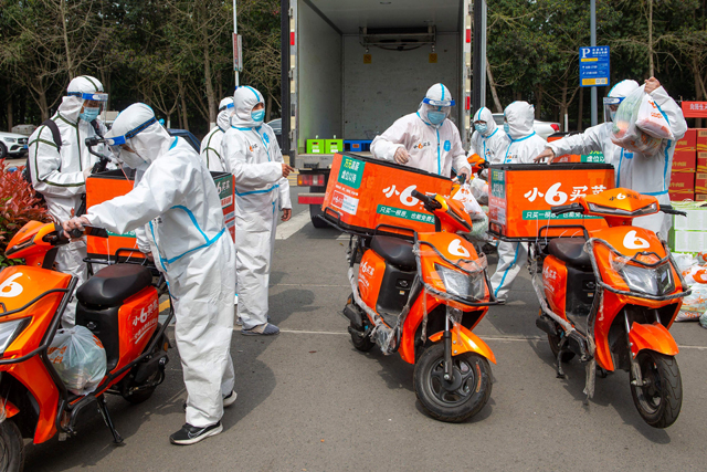 Delivery men wearing personal protective equipment prepare to deliver food bought online for residents who were restricted due to a recent COVID-19 coronavirus outbreak, in Ningbo in China's eastern Zhejiang province, on Saturday (AFP photo)