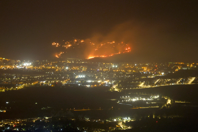A photo shows a fire as a result of rockets launched from Lebanon, next to the northern Israel city of Kiryat Shmona, near the Lebanon border on Friday, amid ongoing cross-border clashes between Israeli troops and Hizbollah fighters (AFP photo)
