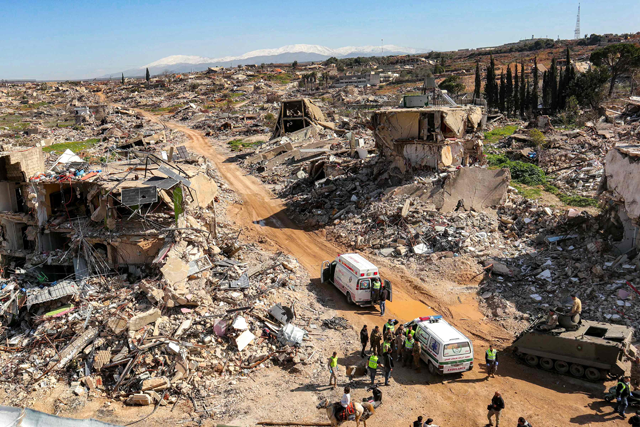Ambulances of charity organisations and Lebanese Army vehicles deploy by rubble of destroyed buildings in the village of Kfar Kila in southern Lebanon on February 18, 2025 after the withdrawal of Israeli troops from the area (AFP photo)