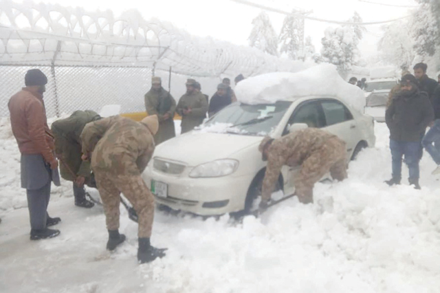 In this handout photograph released by Pakistan's Inter Services Public Relations on Saturday shows soldiers taking part in a rescue operation to clear a road covered with snow in Murree (AFP photo)