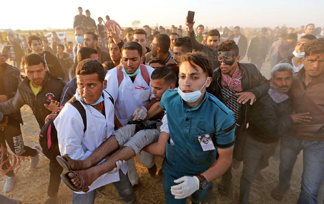 A wounded Palestinian demonstrator is evacuated during a protest along the Israeli-Gaza border demanding the right to return to their homeland, in the southern Gaza Strip, on Monday (Reuters photo)