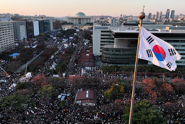 This aerial photograph taken on December 14, 2024 shows the South Korea flag fluttering in the wind as protesters calling for the ouster of President Yoon Suk Yeol celebrate after the impeachment motion against Yoon was passed outside the National Assembly in Seoul (AFP photo)