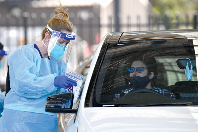 A health worker takes a swab sample from a resident at a COVID-19 drive-through testing clinic in Sydney on Wednesday (AFP photo)