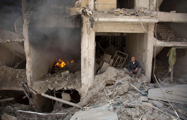 A man sits on the rubble of a destroyed building following reported air strikes by Syrian government forces in the rebel-held Shaar neighbourhood of the northern city Aleppo on Wednesday  (AFP photo by Karam Al Masri)