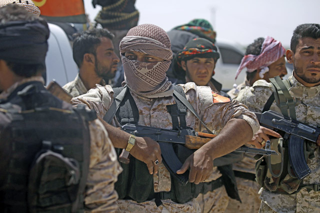 Members of the US-backed Syrian Democratic Forces stand in the village of Hazima on the northern outskirts of Daesh’s Syrian bastion of Raqqa on Tuesday (AFP photo by Delil Souleiman)
