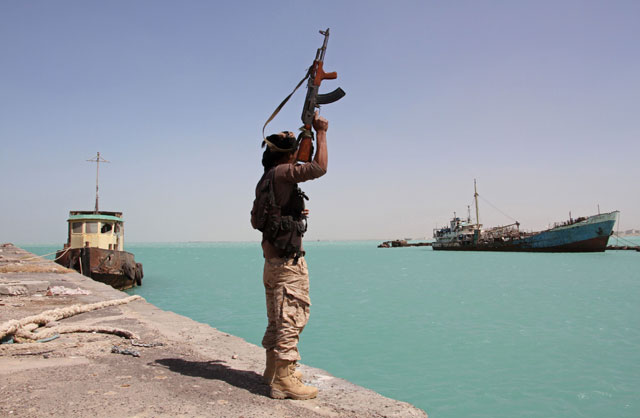 In this file photo taken on February 8, 2017, a member of pro-government forces raises his weapon in the port of the western Yemeni coastal town of Mokha as the Saudi-backed troops advance in a bid to try to drive the Iran-backed Shiite Houthi rebels away from the Red Sea coast (AFP photo)