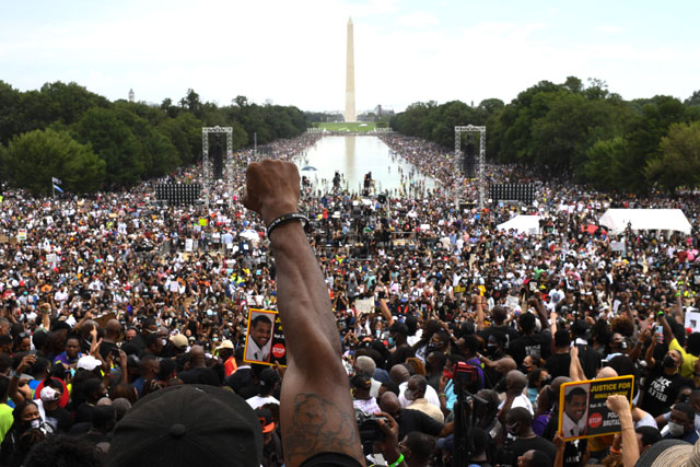 A participant raises his fist during the 'Commitment March: Get Your Knee Off Our Necks' protest against racism and police brutality on Friday, at the Lincoln Memorial in Washington, DC. Anti-racism protesters marched on the streets of the US capital on Friday, after a white officer's shooting of African American Jacob Blake (AFP photo)