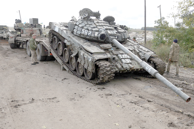 A Russian T-72 tank is loaded on a truck by Ukrainian soldiers outside the town of Izyum on Saturday, as the Ukrainian counter-offensive seized most of the north-east Kharkiv region (AFP photo)