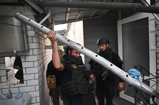 Ukrainian explosive experts carry out from a fragment of a cluster missile damaged house after a Russian strike to small town of Derhachi, Kharkiv region on September 8, 2024, amid the Russian military operations in Ukraine (AFP photo)