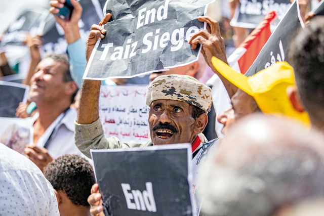 A demonstrator holds a sign reading in English 'end Taiz [Taez] siege' demanding the end of a years-long blockade of the area imposed by Yemen's Houthi rebels on the Yemeni third city on Wednesday (AFP photo)