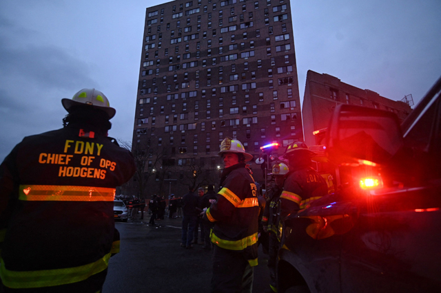 Firefighters work outside an apartment building after a deadly fire in the Bronx, on Sunday, in New York (AFP photo)