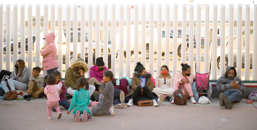 Asylum seekers wait outside El Chaparral border crossing port as they wait to cross into the United States in Tijuana on Friday (AFP photo)