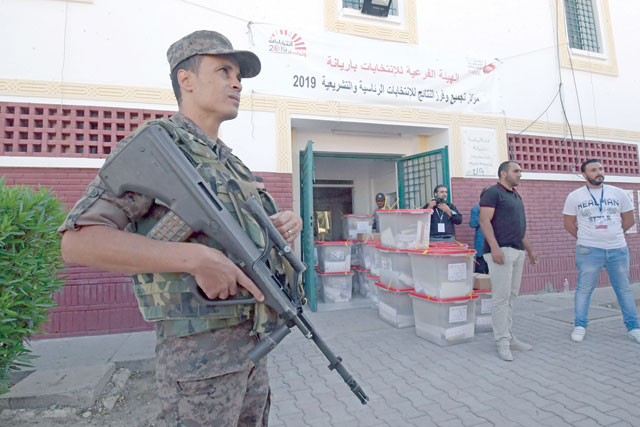 A soldier stands guard as workers of Tunisia's Independent High Authority for Elections dispatch ballot boxes to polling stations in Tunis on Saturday, ahead of Sunday's legislative elections (AFP photo)