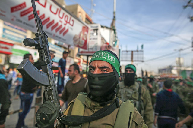 A member of Hamas' armed wing Al Qassam Brigades stands guard carrying a Kalashnikov assault rifle during the funeral of Ziad Al Howajri, one of the members of Hamas' security forces, in Al Nusairat refugee camp, in the central Gaza Strip, on Thursday (AFP photo)