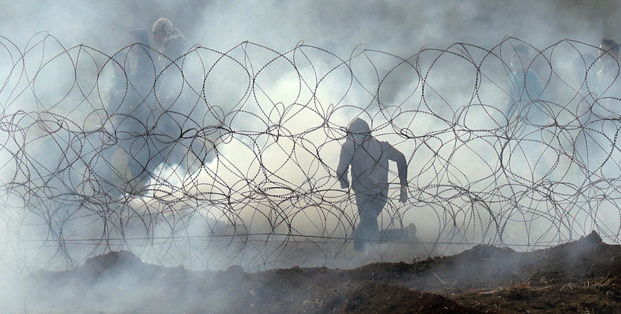 This photo taken on Saturday from the southern Israeli kibbutz of Nahal Oz across the border from the Gaza Strip shows a Palestinian protester running away from the border fence, as Palestinians demonstrate to mark the first anniversary of the 'Great March of Return' protests (AFP photo)