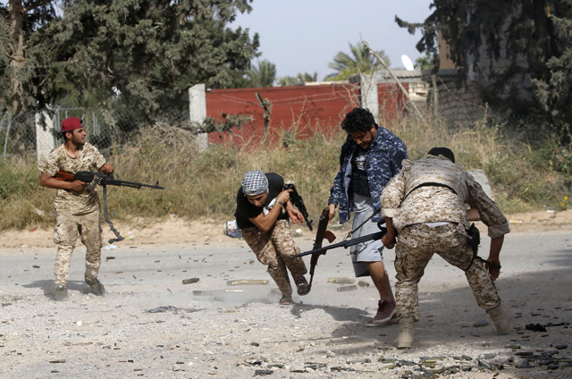   Libyan fighters loyal to the Government of National Accord run as they fire their guns during clashes with forces loyal to strongman Khalifa Haftar south of the capital Tripoli's suburb of Ain Zara, on Saturday (AFP photo)