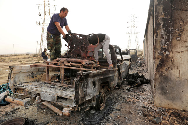   Members of the Libyan internationally recognised government forces inspect the damaged military vehicles, belonging to Eastern forces commanded by Khalifa Haftar, in Al Hira area, southern west Tripoli, Libya, on Tuesday (Reuters photo)
