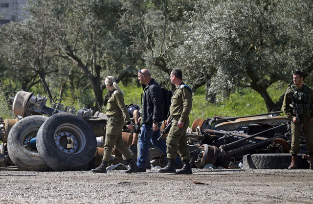 Israeli soldiers inspect the site where a Palestinian man was killed after he allegedly tried to stab an Israeli driver at a junction south of Nablus in the occupied West Bank on Wednesday (AFP photo)