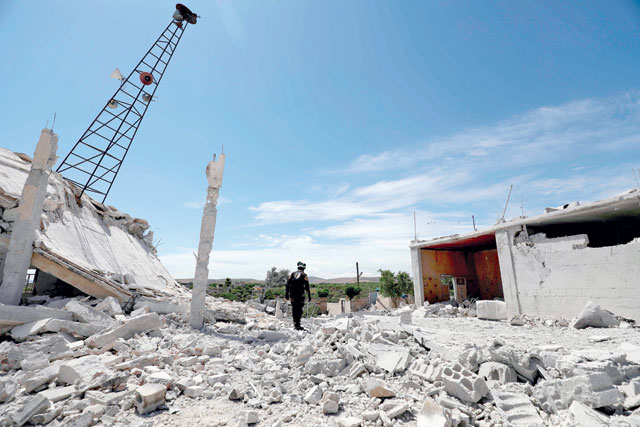 A member of the Syrian Civil Defence (White Helmets) inspects the rubble following shelling by Syrian regime forces and their allies on the village of Maarit Sin in the countryside of the rebel-held Idlib province on Saturday (AFP photo)