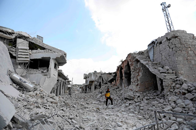   This photo, taken on Friday, shows a man walking amidst the debris of destroyed buildings in the town of Ihsim, in Syria’s Idlib region (AFP photo)