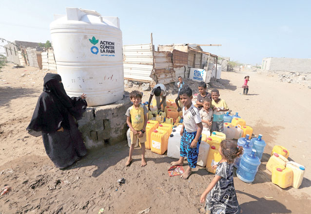 Children wait to fill jerry cans with drinking water on Salam Street in north Hodeida, Yemen, on Monday (Reuters photo)