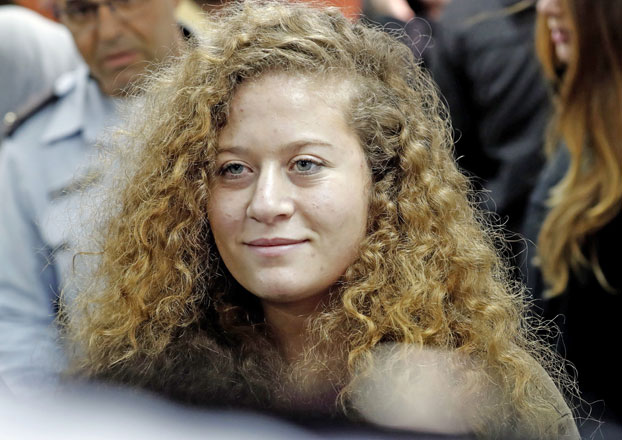 In this file photo taken on February 13, 2018, Palestinian teenager and campaigner Ahed Tamimi arrives for the beginning of her trial in the Israeli military court at Ofer military prison in the West Bank village of Betunia. Tamimi is set to go free today after eight months behind bars (AFP photo)
