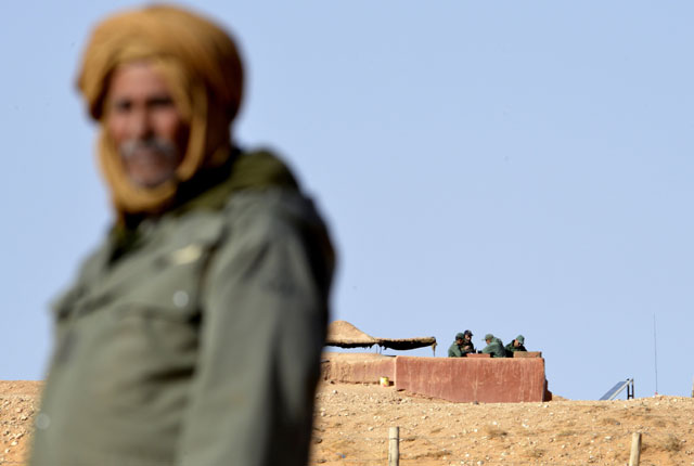 This file photo taken on February 3, 2017, shows a Saharawi man standing in Al Mahbes area near Moroccan soldiers guarding the wall separating the Polisario controlled Western Sahara from Morocco (AFP photo)
