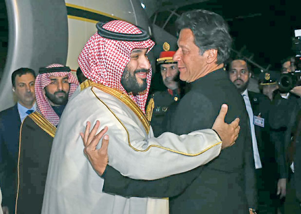 In this handout photo taken and released by Pakistan's Press Information Department on Sunday, Pakistan's Prime Minister Imran Khan (right) greets Saudi Arabian Crown Prince Mohammed Bin Salman (left) upon his arrival at the military Nur Khan Air Force base in Islamabad (AFP photo)