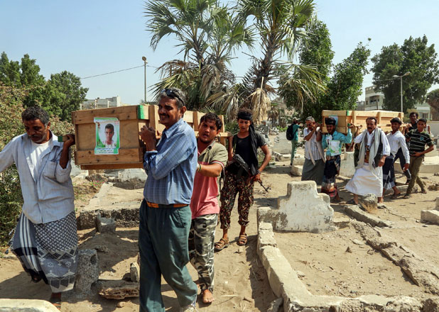 Yemeni mourners walk in a cemetery carrying the coffin of one of the victims of reported bombardment in the Houthi rebel-held Red Sea port city of Hodeida on Monday (AFP photo)
