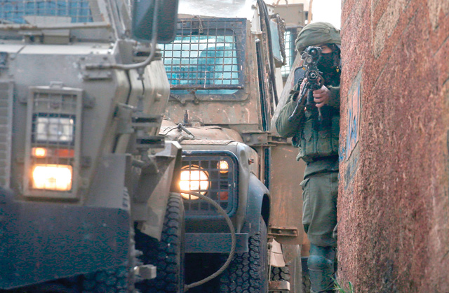 An Israeli soldier stands guard in the northern West Bank village of Salem, east of Nablus, on Monday during a search operation for a Palestinian suspect (AFP photo)