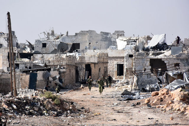 Syrian pro-government forces walk around in the village of Minyan, west of Aleppo, after they retook the area from rebel fighters on Saturday (AFP photo)