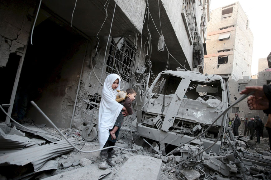 A girl carrying a baby inspects damage at a site hit by what activists said were air strikes carried out by the Russian air force in the town of Douma, eastern Ghouta in Damascus, Syria in this January 10, 2016 file photo (Reuters photo)