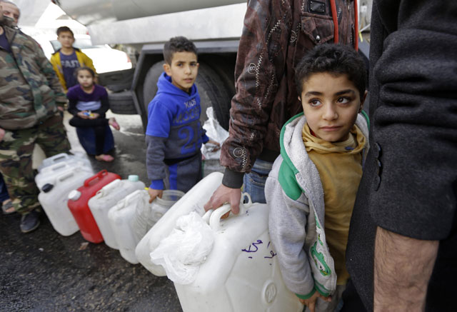 Syrians wait to fill plastic containers with water provided by the Syrian Arab Red Crescent in the capital Damascus on Tuesday (AFP photo)