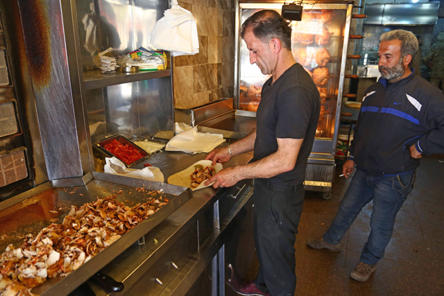 A Syrian man cooks in the northwestern Syrian city of Afrin on Saturday  (AFP photo)