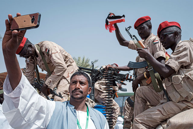   A Sudanese man takes a selfie with members of Sudan's Rapid Support Forces (RSF) paramilitaries led by General Mohamed Hamdan Dagalo, also known as Himediti, deputy head of Sudan's ruling Transitional Military Council and commander of the RSF paramilitaries, during the general's meeting with his supporters in the capital Khartoum on Tuesday (AFP photo)