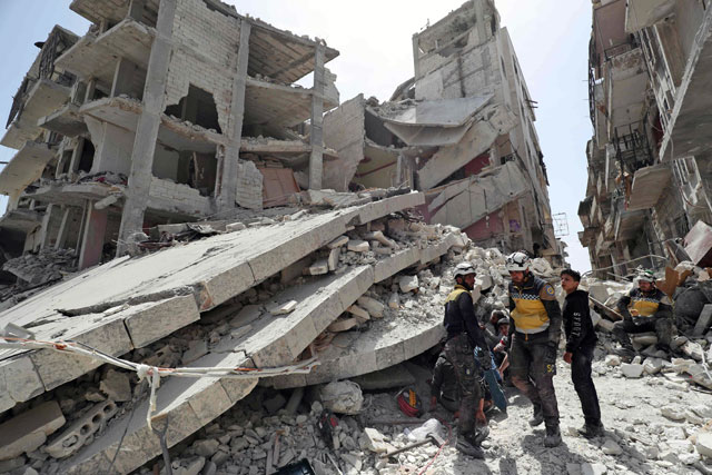 Members of the Syrian Civil Defence, also known as the ‘White Helmets’, search the rubble of a collapsed building following an explosion in the town of Jisr Al Shughur, in the west of the mostly rebel-held Syrian province of Idlib, on Wednesday (AFP photo)