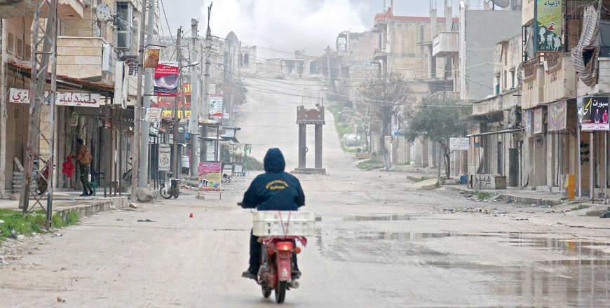 A man rides a scooter on a street during reported air strikes in the town of Khan Sheikhun in the southern countryside of the rebel-held Idlib province, on Friday (AFP photo)