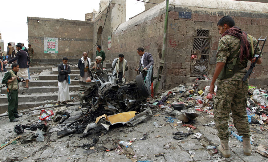 Yemenis surround the wreckage of a vehicle outside the Kobbat Al Mehdi Shiite Mosque in the capital Sanaa on Saturday, after a car bomb targeting the area killed two people (AFP photo by Mohammed Huwais)