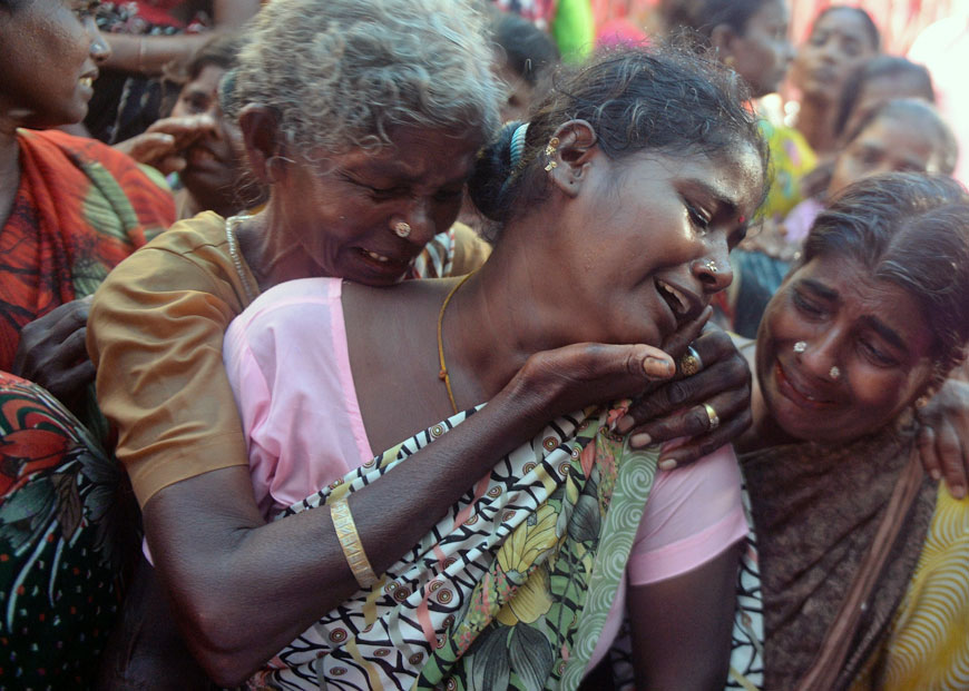 An Indian woman breaks down as she sees the dead body of her family member, a victim of toxic home-made liquor consumption, in Mumbai on Saturday (AFP photo)