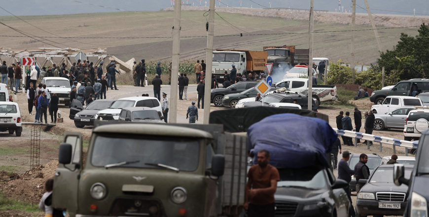 Refugees wait after crossing the border and arriving at a registration centre of the Armenian foreign affairs ministry, near the border town of Kornidzor, on Monday (AFP photo)