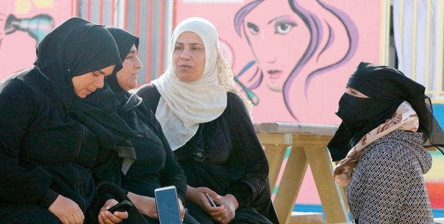 Syrian refugees sit on a bench at the Azraq camp for Syrian refugees in northern Jordan on Thursday (AFP photo by Khalil Mazraawi)