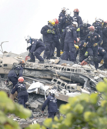 Members of the South Florida Urban Search and Rescue team look for possible survivors in the partially collapsed 12-storey Champlain Towers South condo building on Friday in Florida (AFP photo)