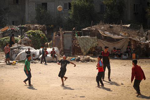 Palestinian youths play football outdoors in a poor neighbourhood in Gaza amid soaring temperatures and power cuts on July 31 (AFP photo)