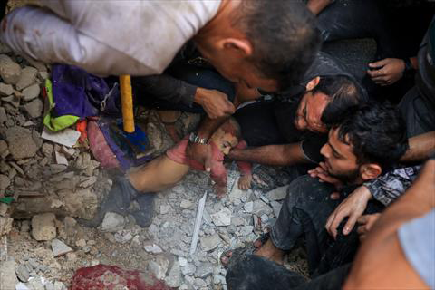 Palestinians pull a child from debris following an Israeli bombardment in Rafah in the southern Gaza Strip on Tuesday (AFP photo)
