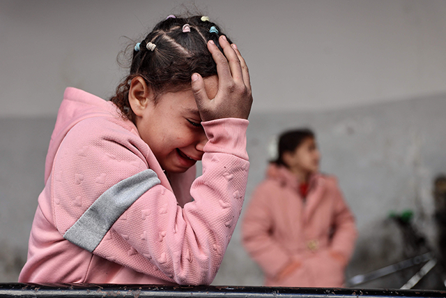 A Palestinian child mourns the death of members of the Ghoula family to the Al-Ahli Arab hospital, also known as the Baptist hospital, after their home was hit in an Israeli strike in the Shujaiya neighbourhood of Gaza City, in the northern Gaza Strip on January 4, 2025 (AFP photo))
